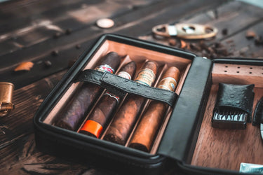 Open black cigar travel case with five cigars held by a strap and the lighter in the lid
