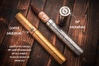 Gold and silver cigar tubes with a cigar, showing engraving on the center band and the cap top
