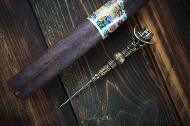 Sheriff cigar needle lying across a cigar on a wooden table