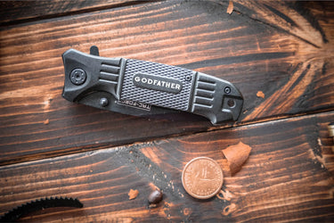 Close view of the black knife handle engraved with a one-word title
