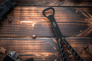 Black flip action bottle opener with two initials engraved on the handle
