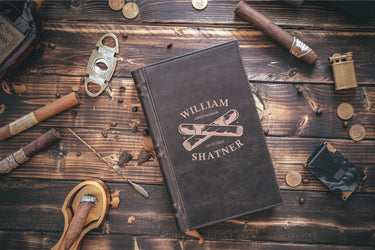 Closed book style cigar case engraved with a name, a date and a crossed-cigars design
